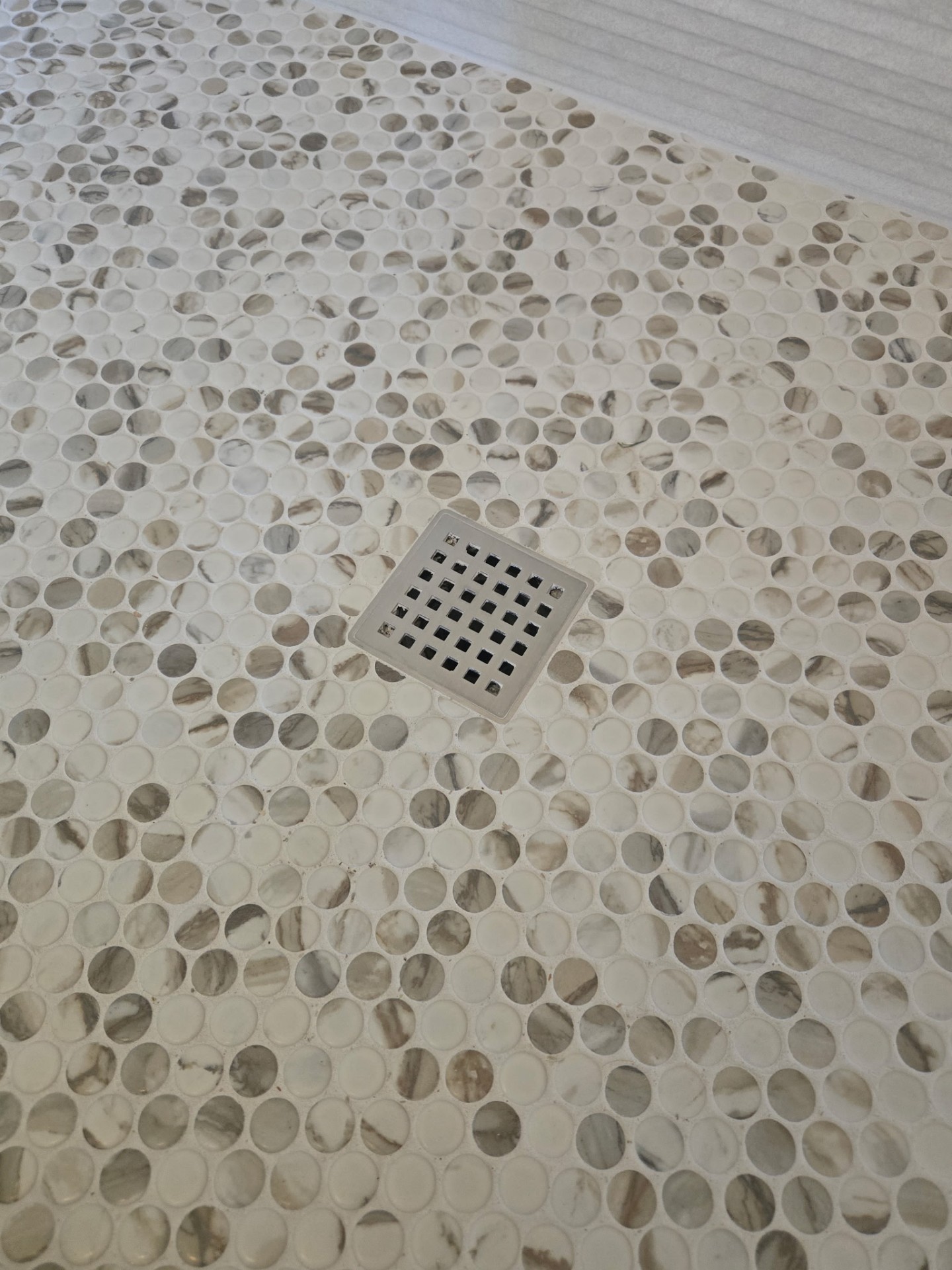 Marble penny-round mosaic shower floor with square brushed nickel drain