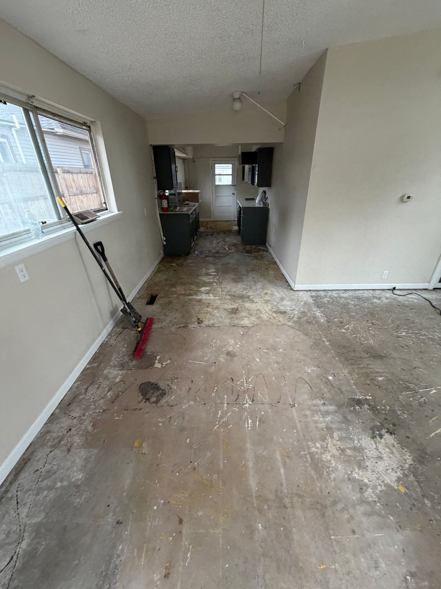 Open living and kitchen flooring renovation — Before