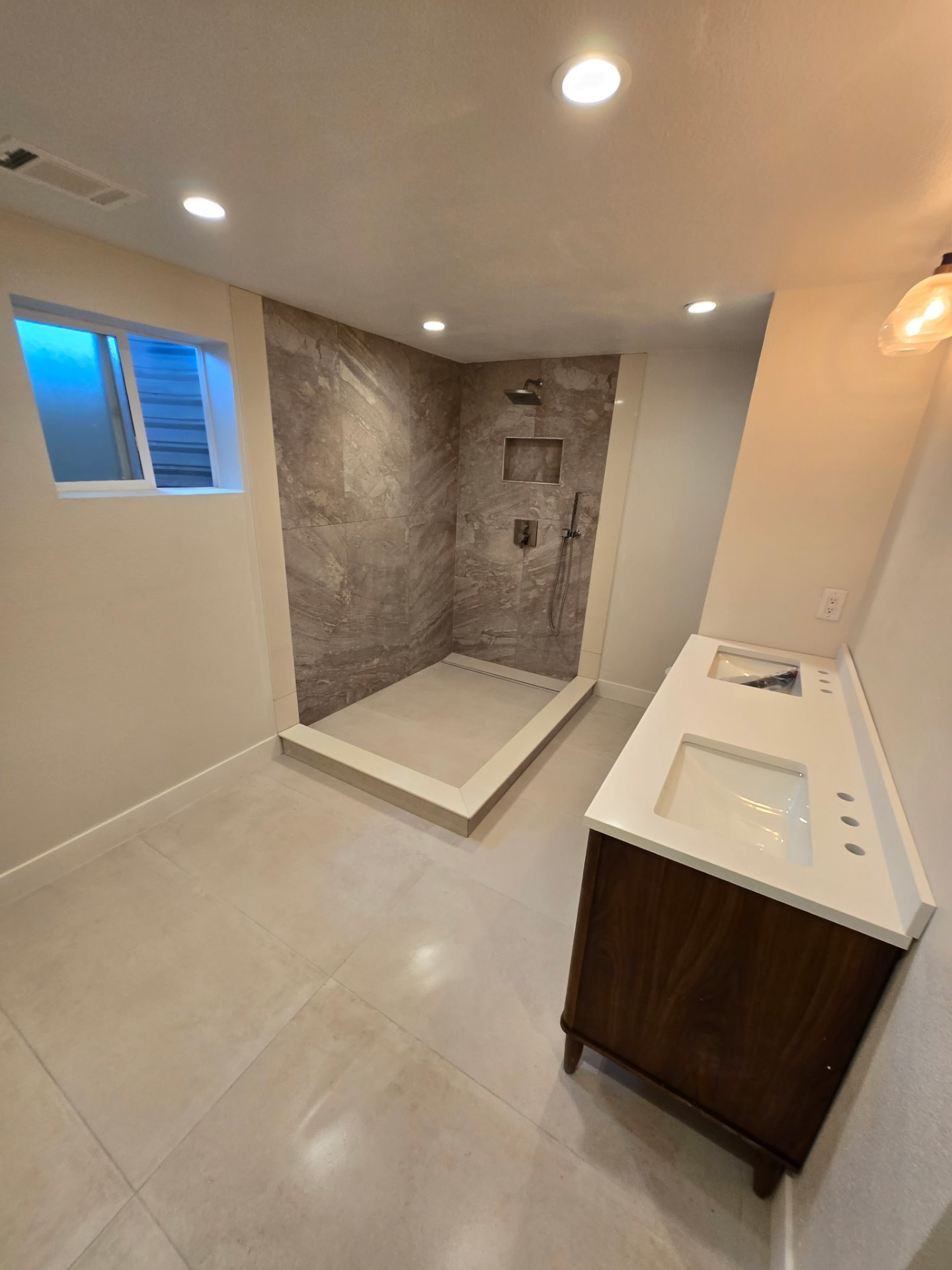 Bathroom remodel with large-format stone shower walls and a walnut double vanity