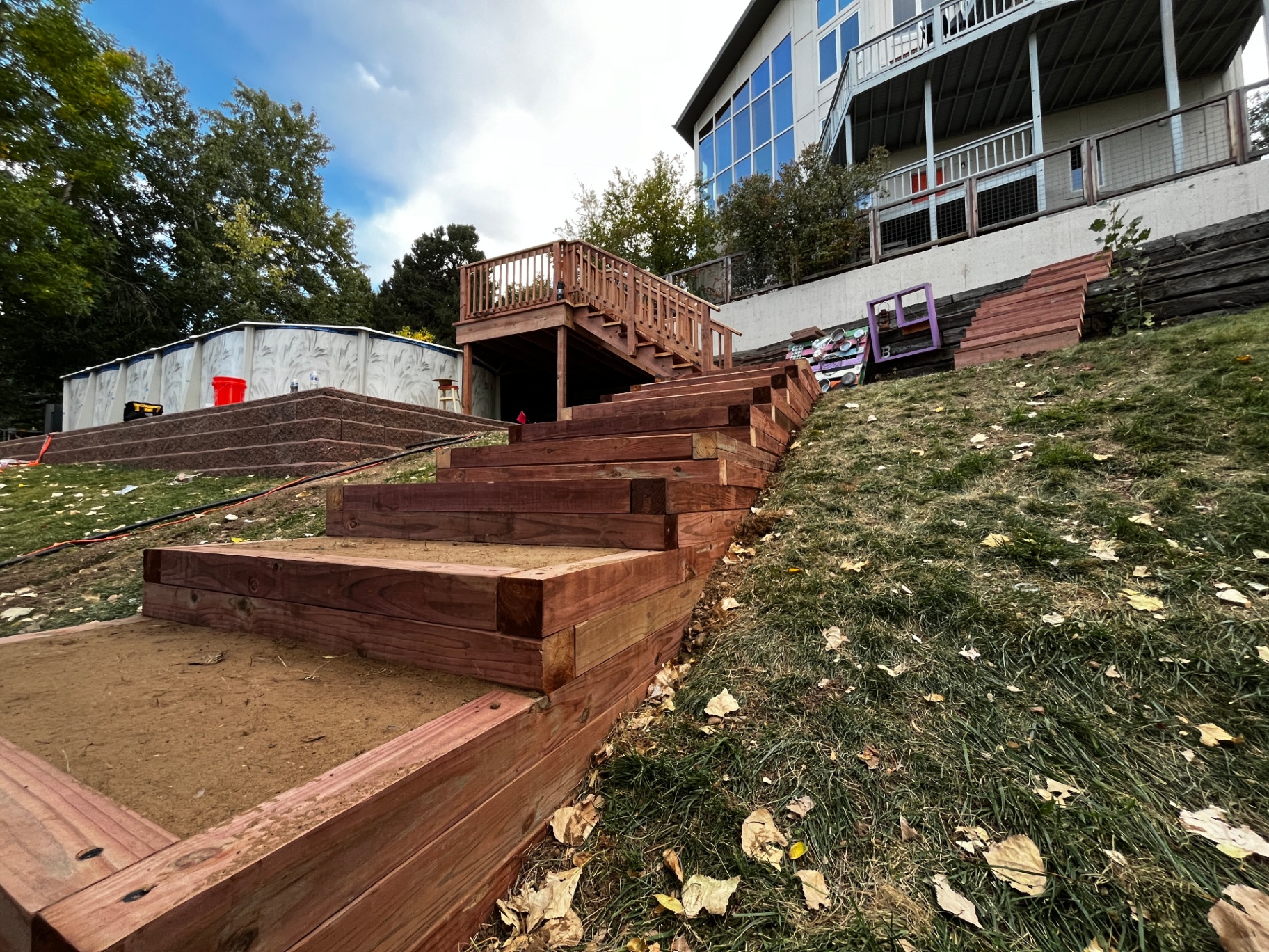 Redwood timber stairs and retaining wall built into a hillside backyard