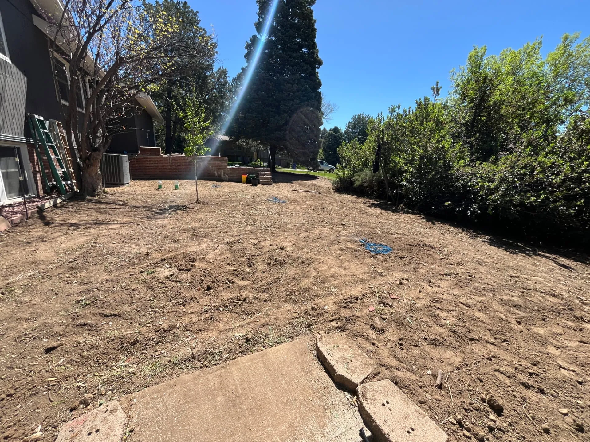 Wide view of a finished backyard rough grade with smooth soil ready for sod
