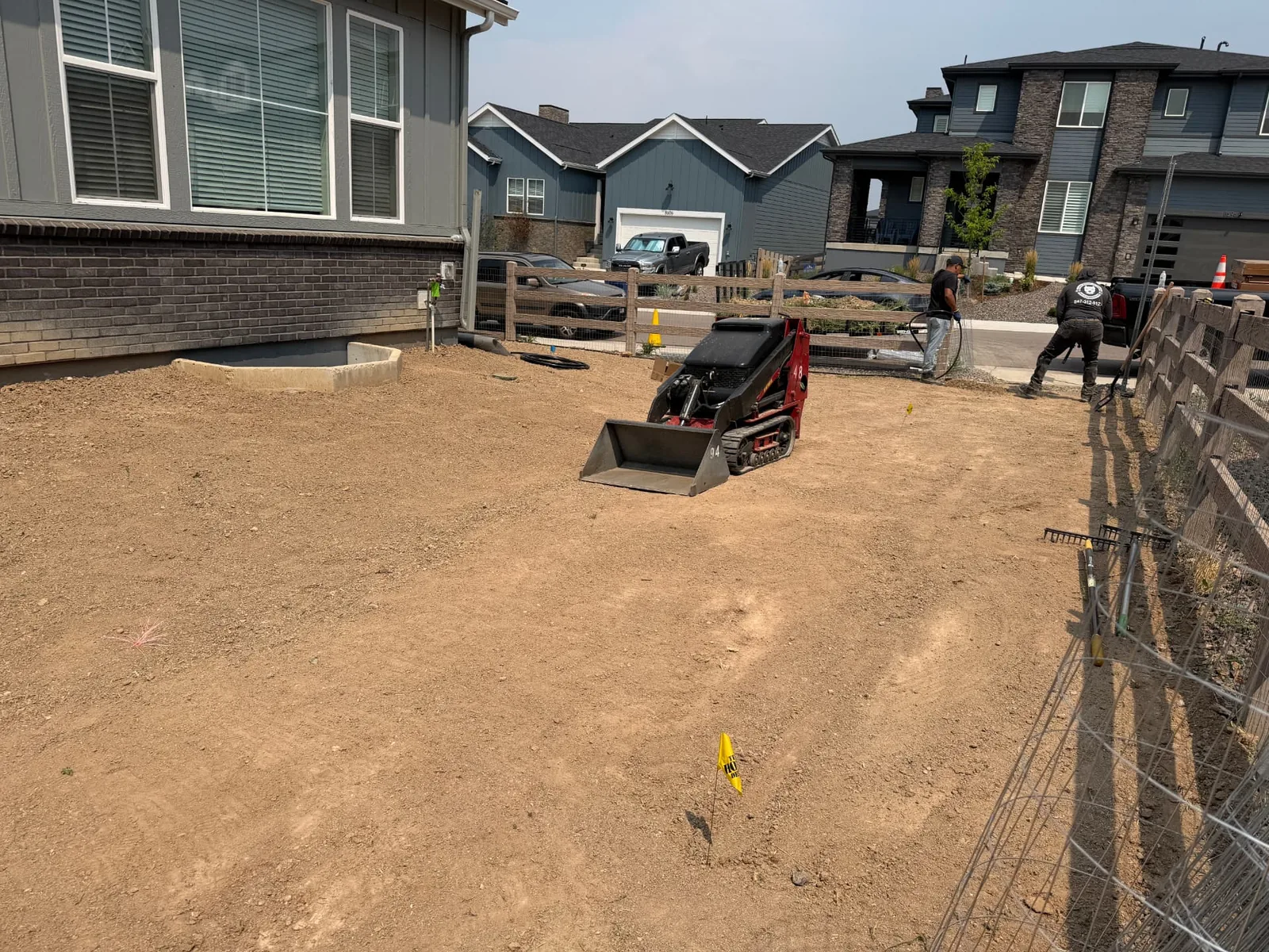 Compact track loader rough grading a residential dirt lot on a Front Range property