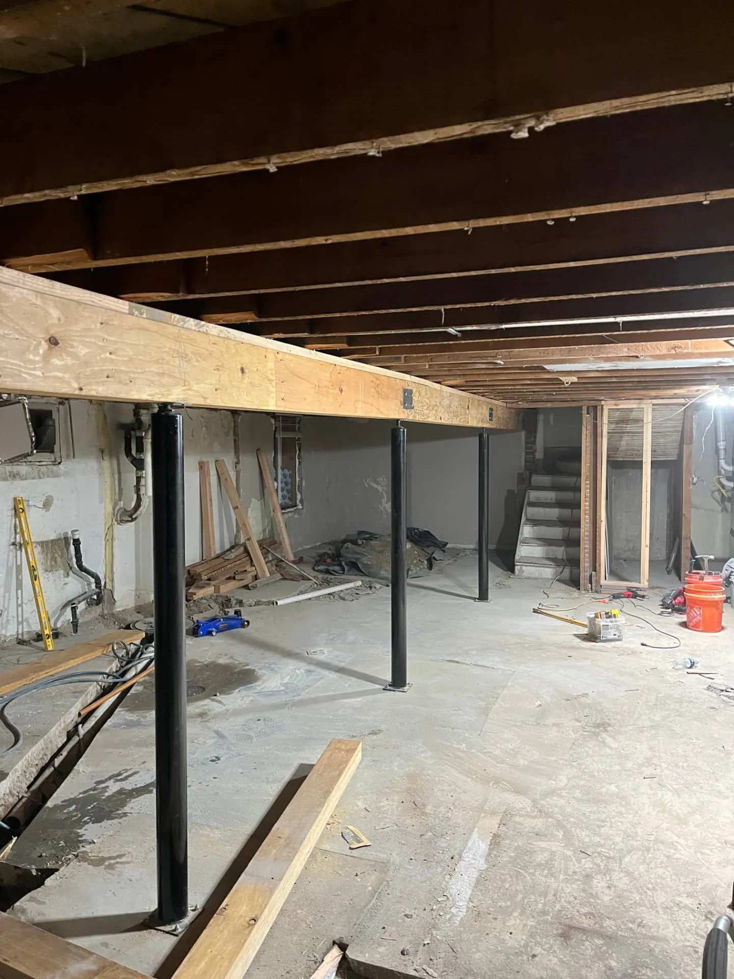 Engineered beam carried on black steel columns during a structural remodel