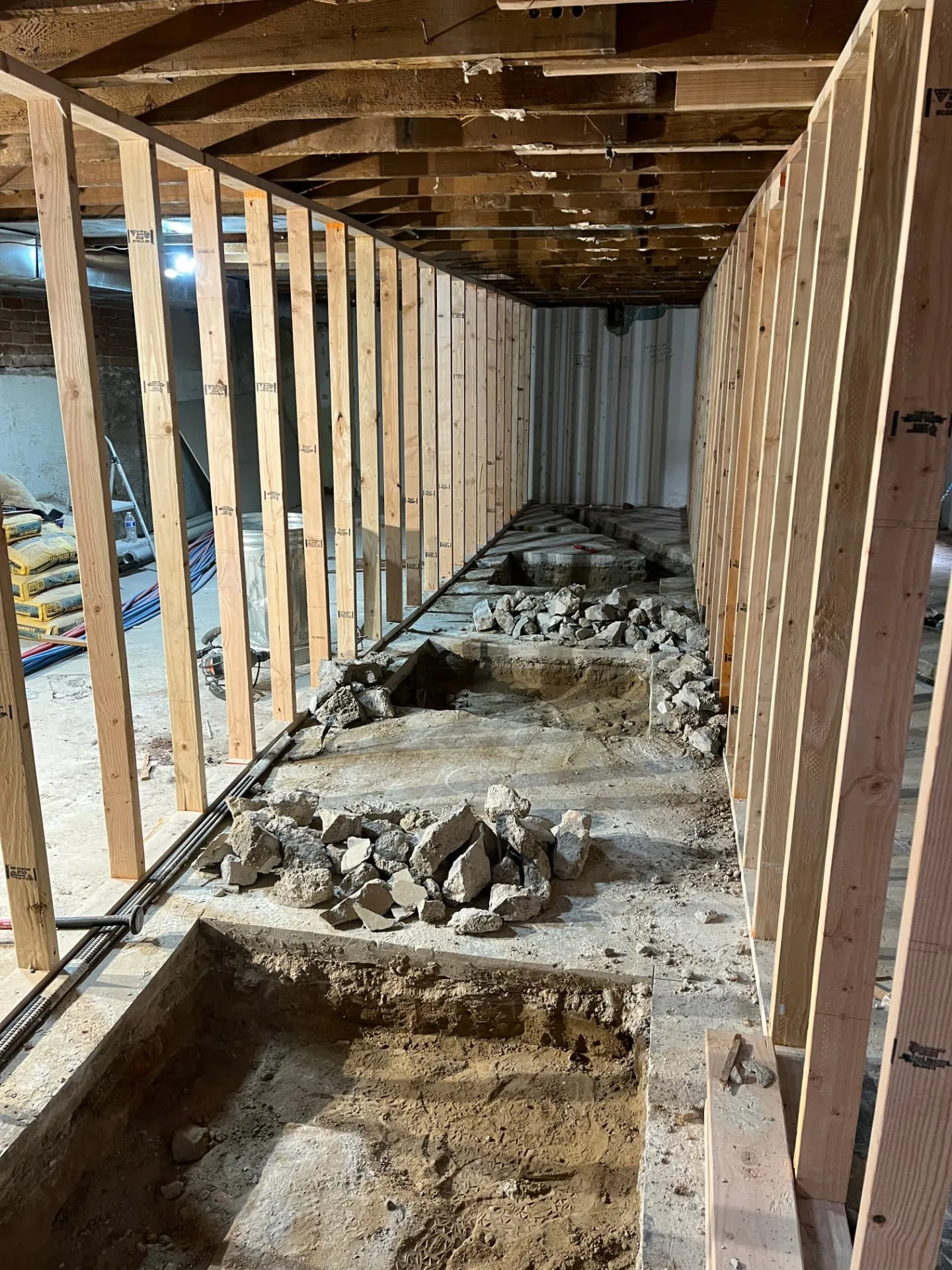 Concrete slab cut and trenched for new under-slab plumbing between framed walls