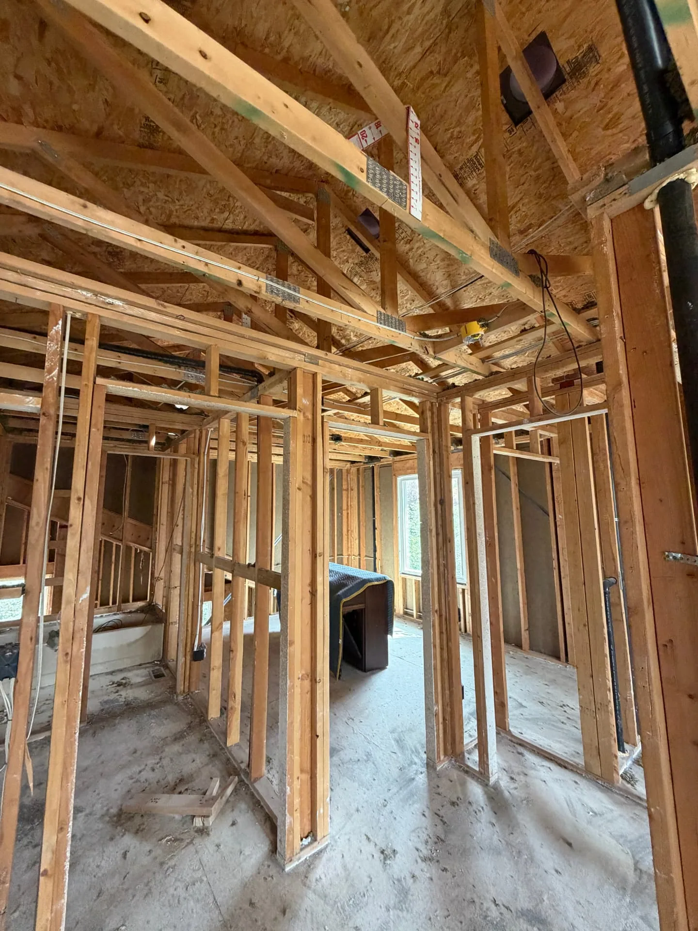 Vaulted ceiling framing and new interior stud walls during a fire-damage rebuild in Highlands Ranch