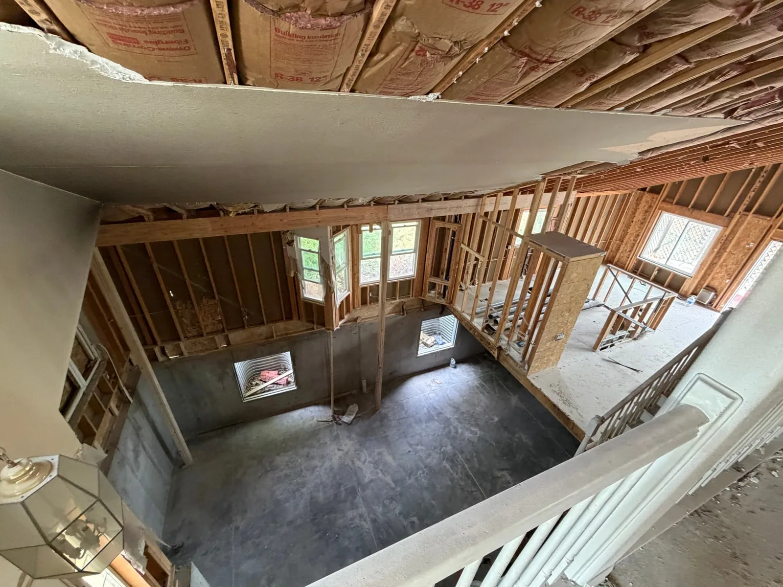 Fire rebuild framing viewed from the upper landing with R-38 ceiling insulation and open-to-below great room