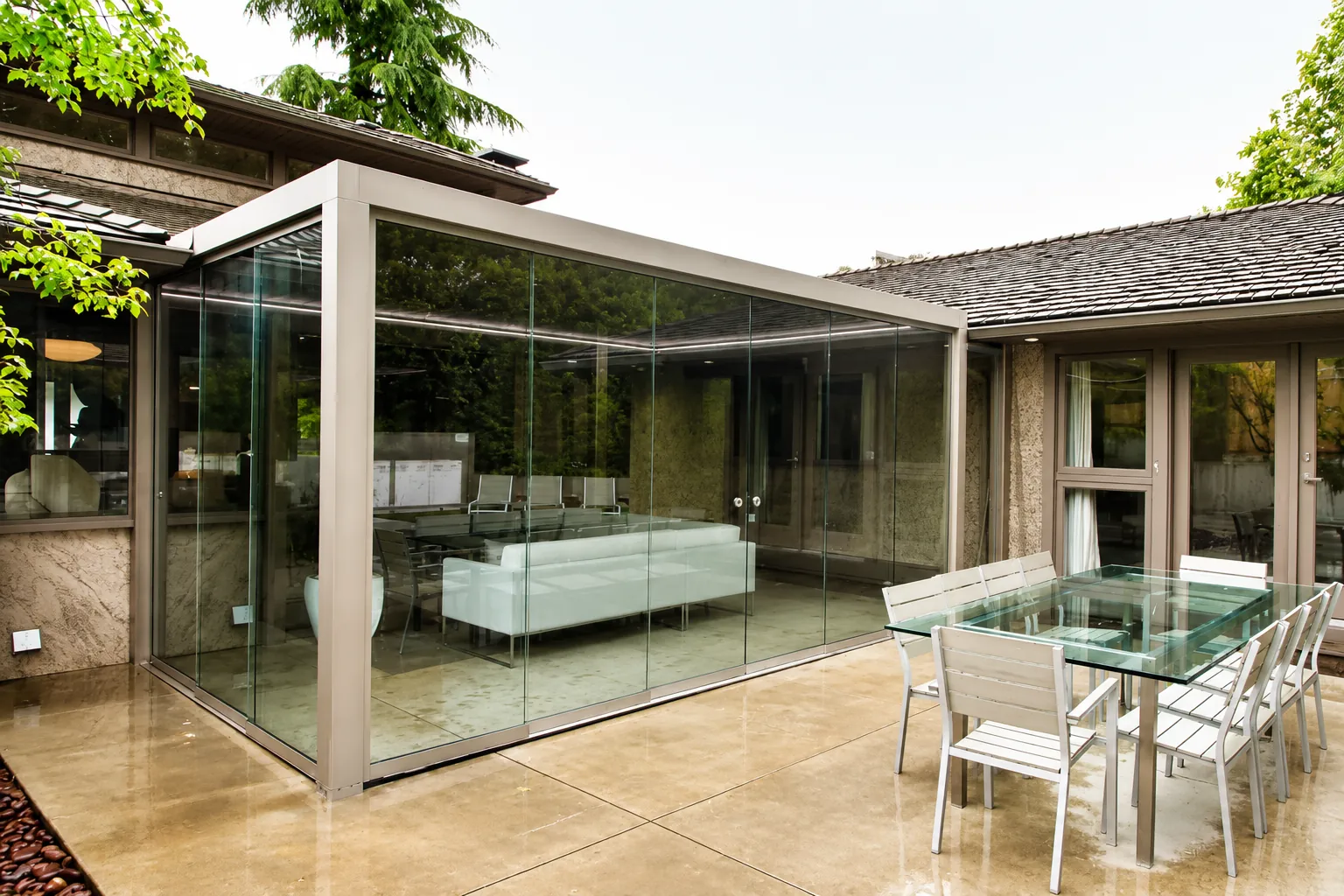 Frameless sliding glass patio enclosure installed on a Colorado home