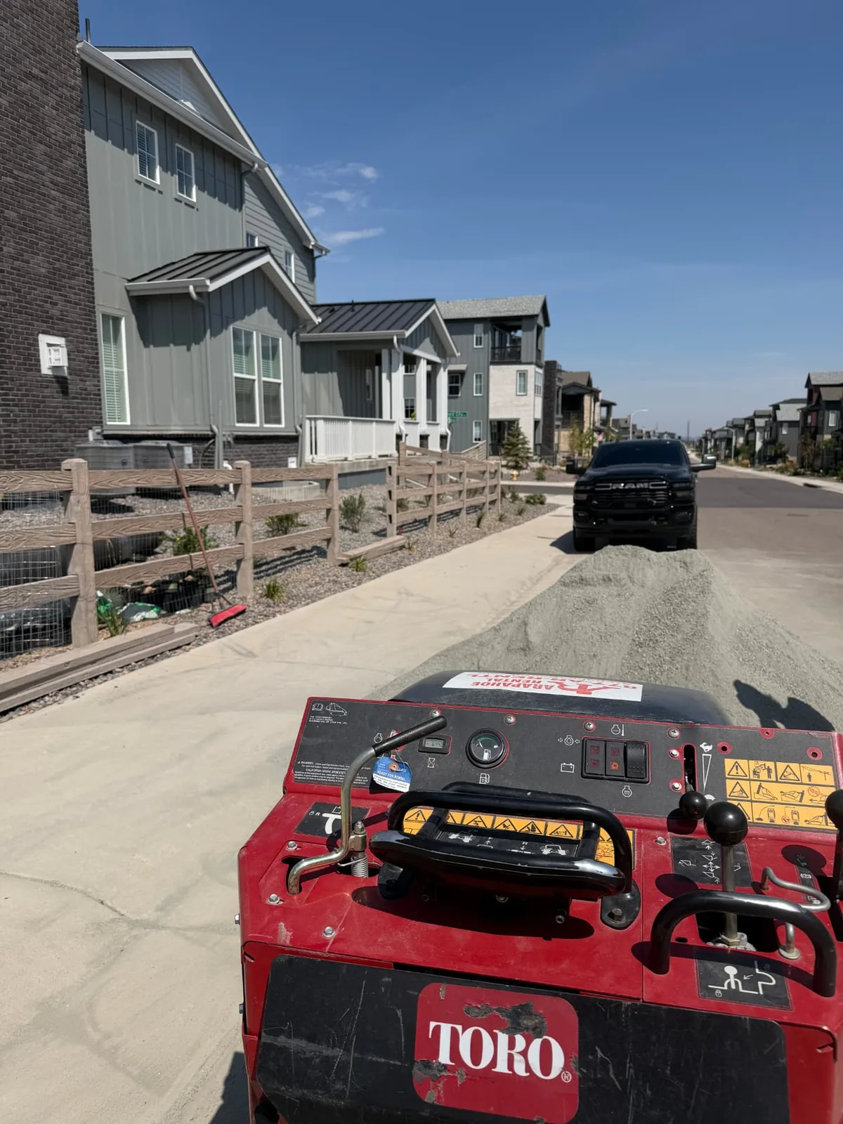 Compact utility loader moving bedding sand for a residential hardscape base