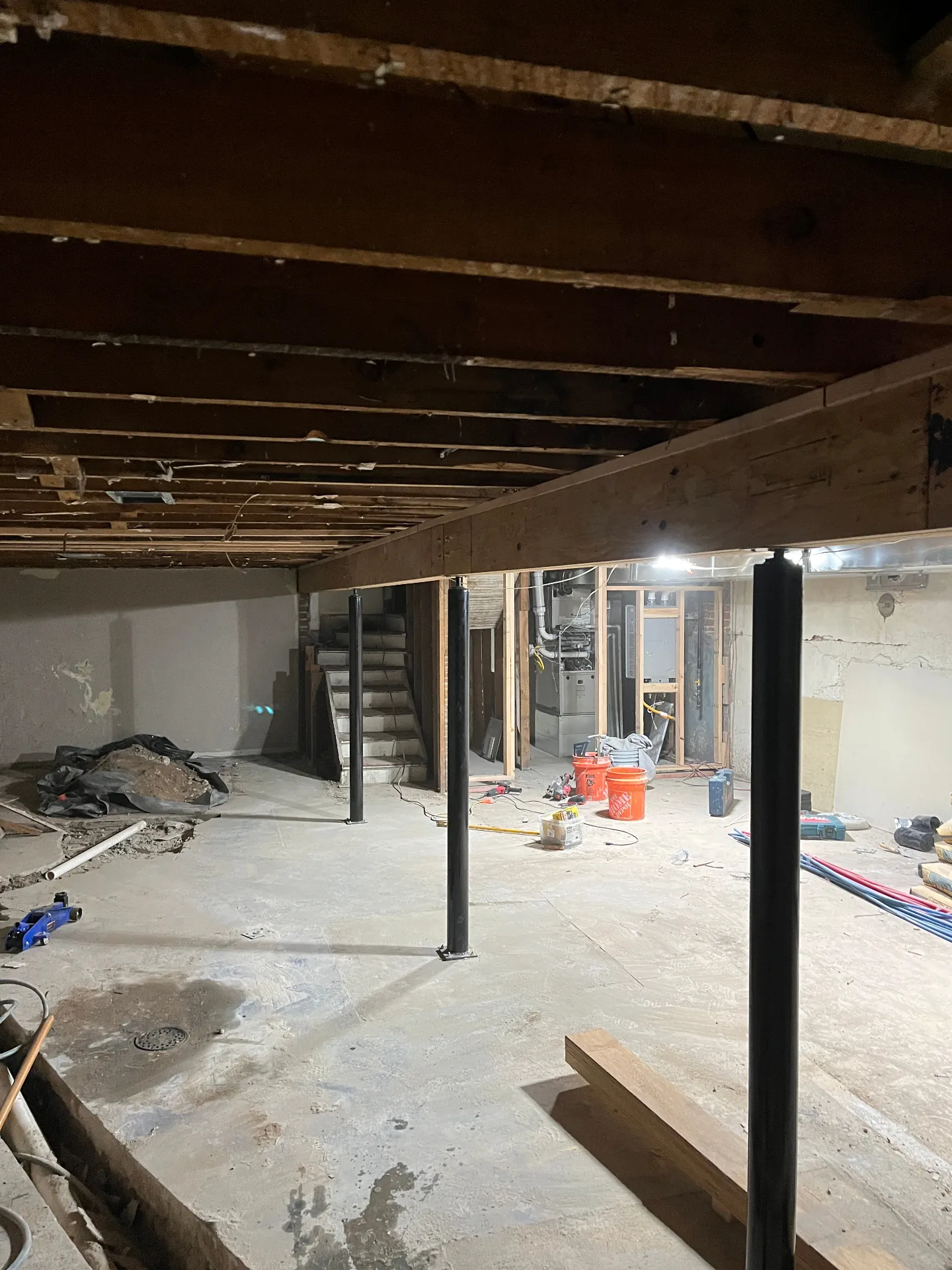Basement after main beam replacement with new beam and steel support posts in place