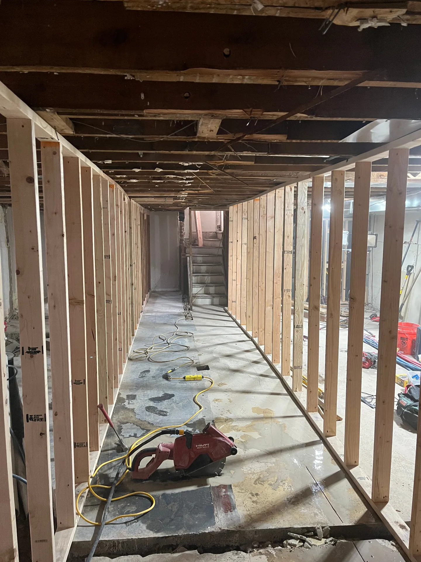 Basement during main beam replacement with new framing installed along the support line
