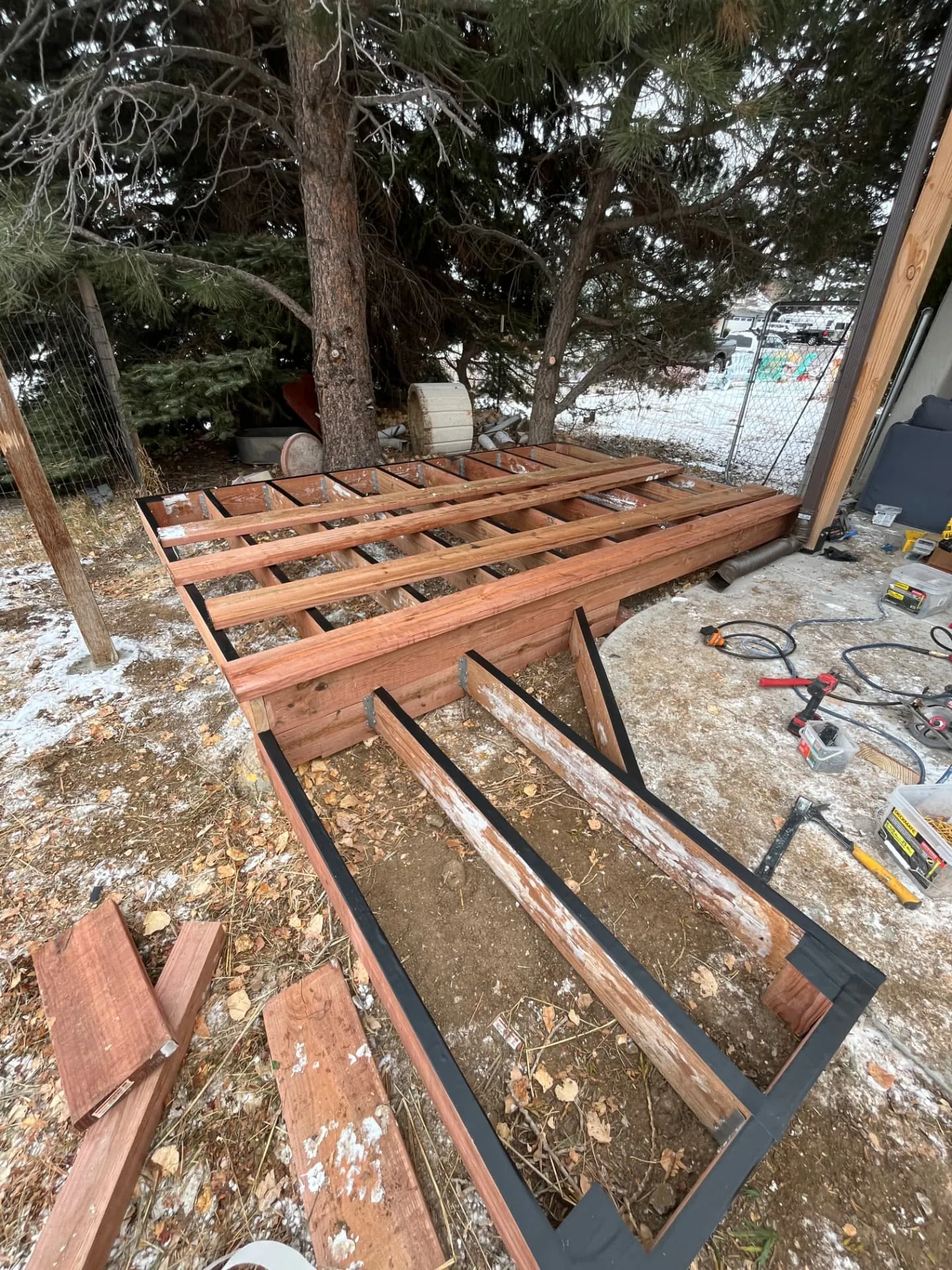 Redwood deck joist framing with joist tape and galvanized hangers before decking